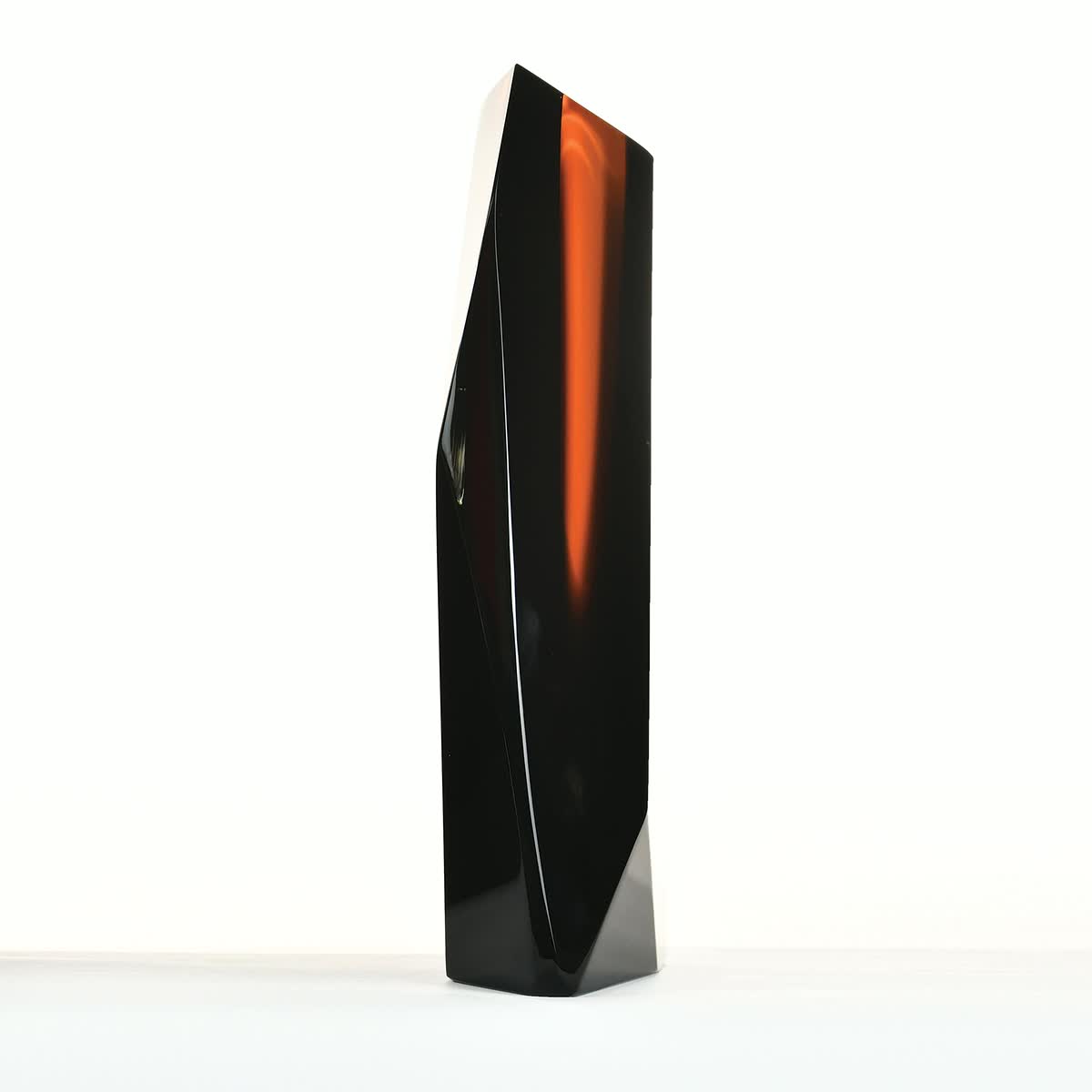 Iconic Orange 01: volume nero a spigoli vivi con una lama di vetro arancio all'interno