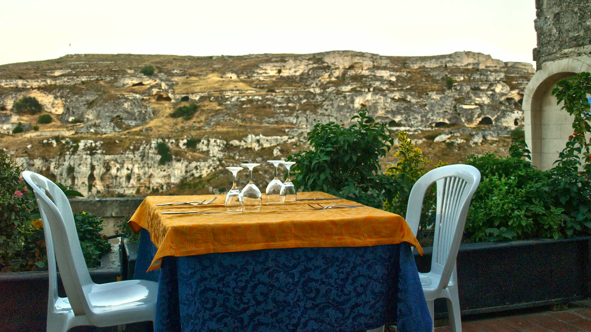 Tavolo apparecchiato sulla terrazza panoramica de I Due Sassi, davanti alla Gravina di Matera