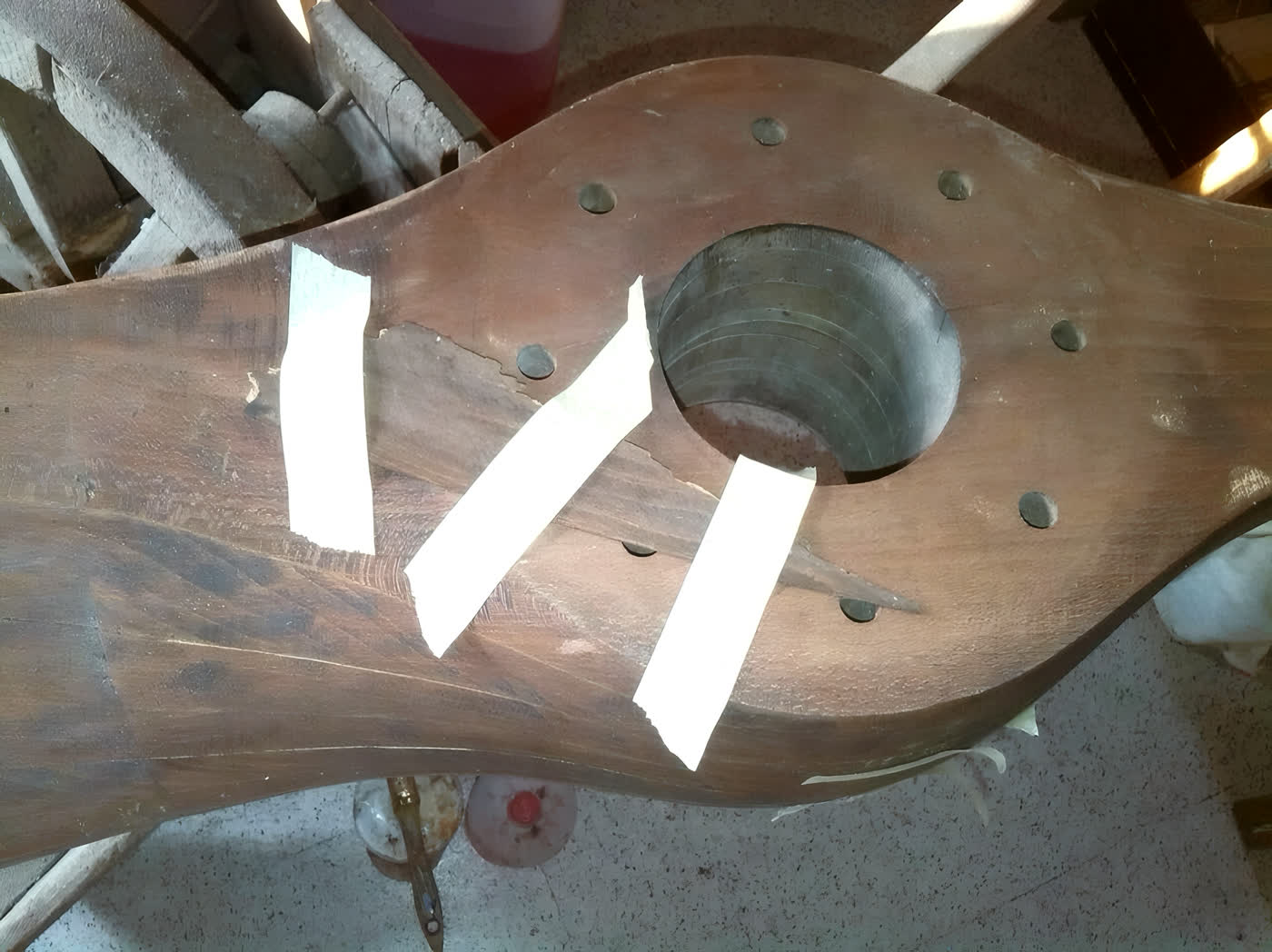 Elemento in legno in lavorazione sul banco della bottega, con segnature a nastro sui punti da riprendere