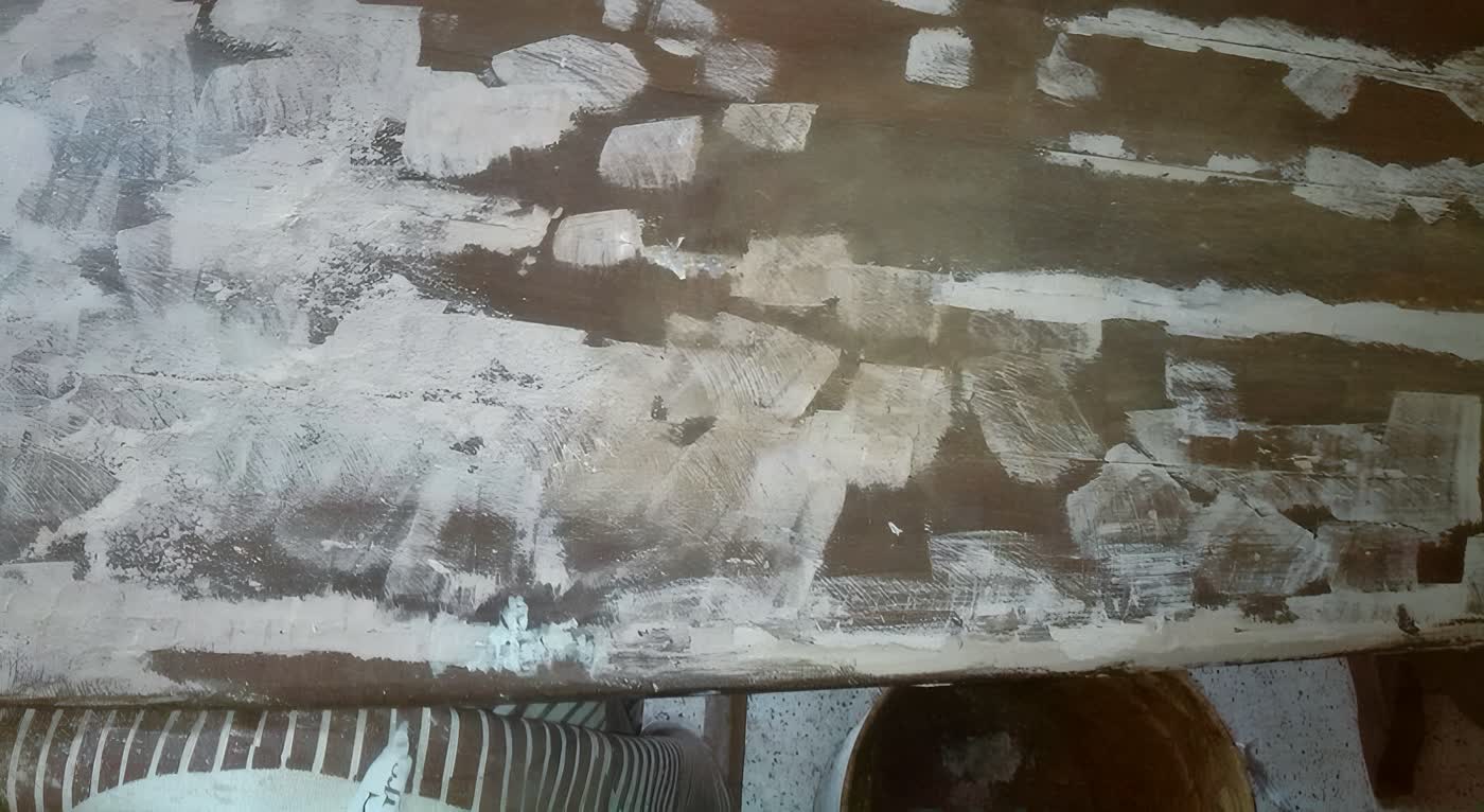 Piano in legno durante la stuccatura, con lo stucco chiaro steso sulle mancanze